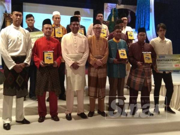 Abdul Basith (depan, tiga dari kiri) bersama penerima bantuan pendidikan dan bantuan lapan van mobiliti OKU memudahkan pengangkutan golongan warga emas di pusat jagaan khususnya mereka yang terlantar mendapatkan rawatan harian di hospital.