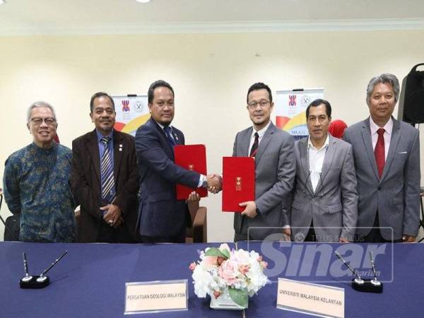 Noor Azizi (kanan) dan Rasid (kiri) bertukar dokumen MoU yang ditandatangani hari ini.