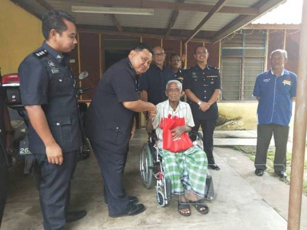 Muhd Nurhishamuddin (dua kiri) menyampaikan sumbangan kepada SM(B) Nordin Ayub di Kampung, Bukit Kelulut, Jempol.