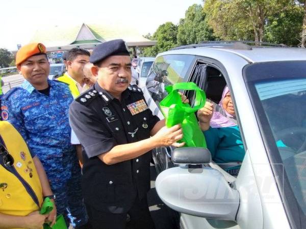 Noorzainy menyampaikan cenderahati kepada pemandu kenderaan pada Kempen Keselamatan Jalanraya: Op Selamat 15/2019 peringkat IPDSPU di Plaza Tol Bertam hari ini.
