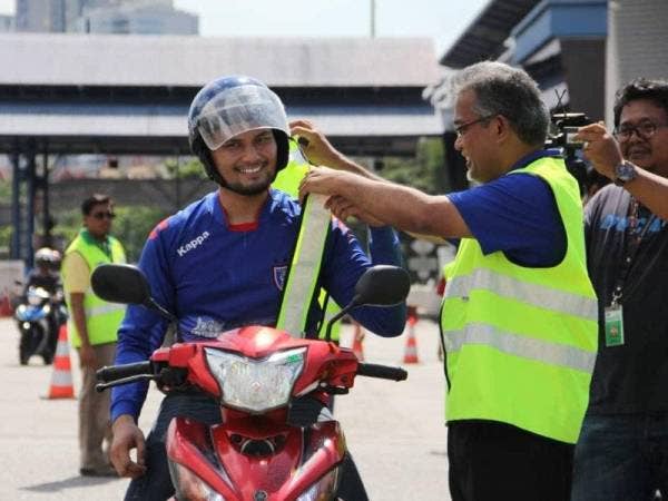 Ir Rostam memakaikan jaket kenderaan kepada pengguna motosikal sempena Pelancaran Kempen Keselamatan Balik Raya PROLINTAS sempena sambutan Aidilfitri di Plaza Tol Datuk Keramat (arah Ampang) AKLEH hari ini.
