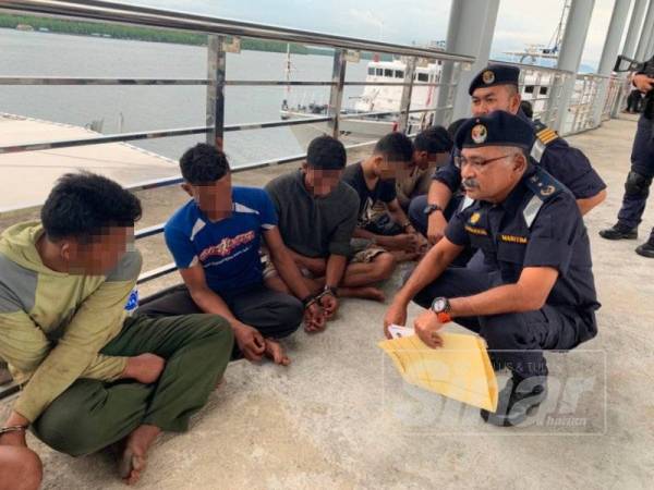 Aminuddin (kanan) ketika menyoal siasat kesemua individu yang ditahan dalam operasi berkenaan.