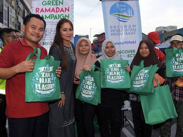 Duta Ikon River of Life (ROL) Maya Karin menyerahkan beg 'Aku Tak Nak Plastik' kepada sebahagian penduduk setempat yang hadir di Bazaar Ramadan Jalan Raja Alang Kampung Baru pada Majlis Kempen Ramadhan Hijau hari ini. - Foto Bernama