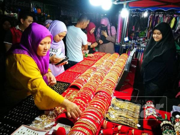 Pengunjung memenuhi gerai emas sadur Korea di bazar raya Pekan Batu Enam.