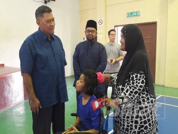 Dzulkefly (kiri) beramah mesra dengan salah seorang penerima.