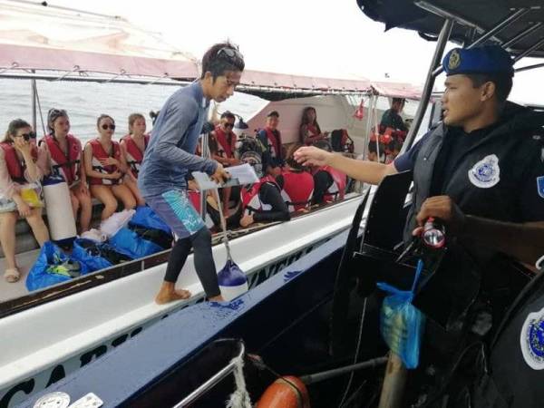 Anggota dan Pegawai PPM Semporna melakukan pemeriksaan dokumen ke atas bot penambang dan pelancong. - FOTO PPM SEMPORNA