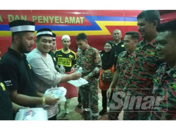 Kamarul Ariffin (tiga, kiri) menyampaikan sumbangan pek makanan.