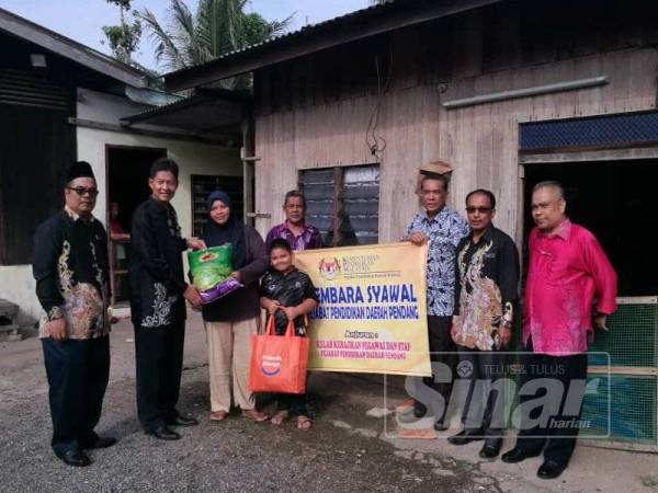 Wakil PPD Pendang menyampaikan sumbangan kepada keluarga salah seorang pelajar.