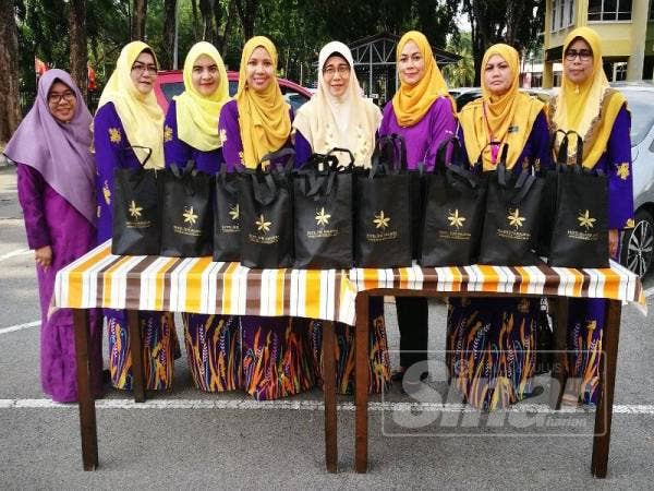Rohana (empat dari kanan) bersama ahlinya mengagihkan bubur lambuk minggu lalu.