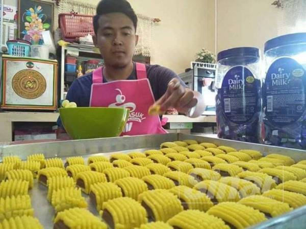 Fitry tekun menyiapkan tempahan biskut raya.