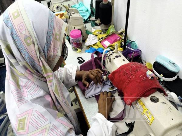 Zairihan Zainuddin, 43, tekun menyiapkan tempahan dari pelanggannya ketika ditemui di rumahnya di Flat PPR Taman Jasmin. - Foto Bernama