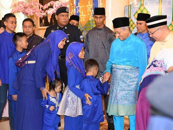 Perdana Menteri Tun Dr Mahathir Mohamad bersama isteri Tun Dr Siti Hasmah Mohamad Ali beramah mesra dengan orang ramai termasuk tetamu cilik pada Majlis Rumah Terbuka Aidilfitri Perdana Menteri dan Ahli Jemaah Menteri di Seri Perdana hari ini.- Foto Bernama