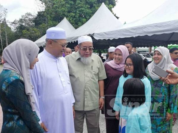 Ahmad (dua dari kiri) beramah mesra dengan tetamu yang hadir di rumah terbukanya di Kampung Alor Pasir, Wakaf Bharu, Tumpat hari ini.