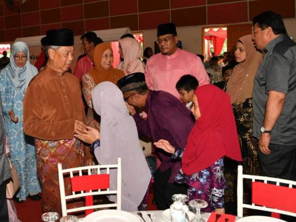 Menteri Dalam Negeri Tan Sri Muhyiddin Yassin dan isteri Puan Sri Noorainee Abdul Rahman bersalaman dengan orang ramai yang mengunjungi Majlis Sambutan Hari Raya Aidilfitri Peringkat Parlimen Pagoh di Dewan Orang Ramai Felda Sri Ledang hari ini. - Foto Bernama