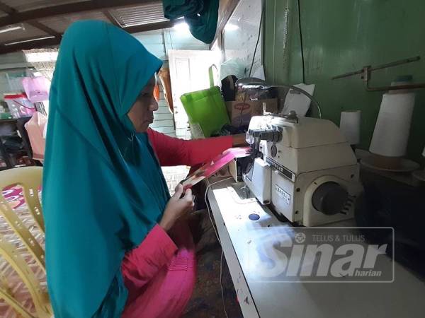 Zalifah mencari rezeki buat keluarganya dengan mengambil upah menjahit.V