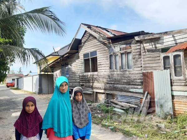 Zalifah dan dua anaknya sayu menunjukkan rumah daif yang mereka huni.