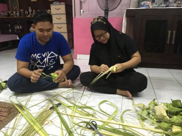 Anak lelaki Aziyan, Muhammad Zikri turut tidak ketinggalan membantu menganyam daun ketupat.
