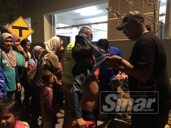 Anak-anak gelandangan menerima sumbangan baju raya oleh NGO yang prihatin.