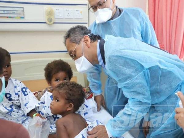 Dr Dzulkefly (kanan) bertanya khabar keadaan kesihatan semasa anak-anak orang asli yang dirawat di hospital.