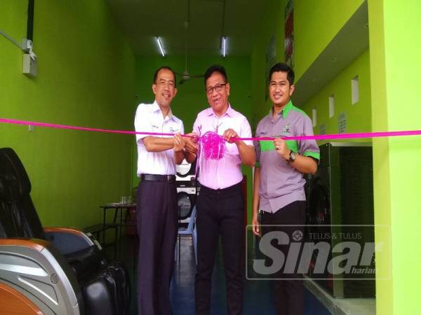 Norhizam (tengah) memotong riben sebagai simbolik menyempurnakan pembukaan Dobi Layan Diri Taman Angkasa Nuri, di Durian Tunggal di sini hari ini.