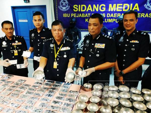 Zulkifli (tengah) menunjukkan dadah yang disorok dalam mangkuk cendol