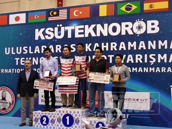 Amer dan bapanya menaiki podium ketika diumumkan juara Pertandingan Robotik Antarabangsa KSUTEKNOROB di Turkey pada Mei yang lalu.