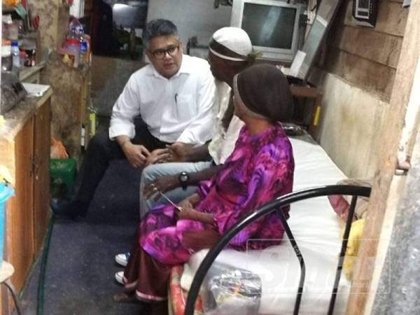 Mahmood (kiri) meninjau keadaan dalam rumah dihuni Hussin (tengah) dan ibunya di Jalan Tupai, Taiping sejak empat tahun lalu.