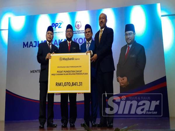 Che Mat (kiri) bersama Mujahid ketika menerima replikan bayaran zakat daripada syarikat-syarikat kepada Pusat Pungutan Zakat MAIWP pada Majlis Zakat Korporat 2019 di Bangi.