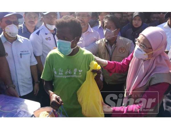 Dr Wan Azizah (kanan) menyampaikan bantuan kit makanan kepada masyarakat orang asli di Kuala Koh.