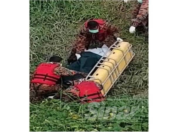 Anggota bomba membantu mengusung mayat mangsa yang ditemui di Sungai Putat, petang semalam.