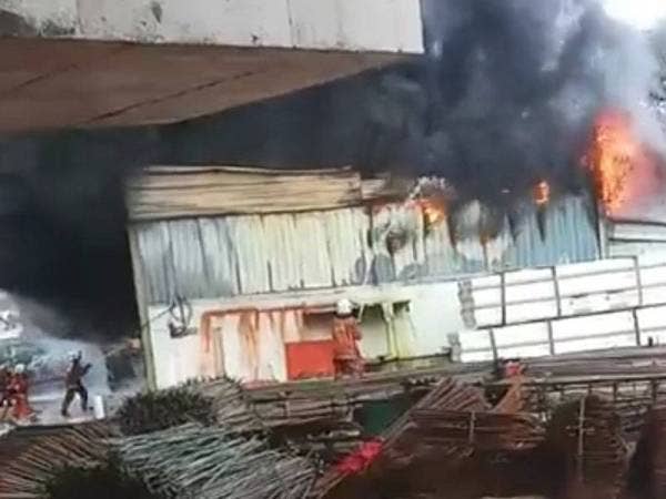 Anggota Bomba dan Penyelamat giat memadamkan kebakaran kedai bahan binaan di Jalan Bukit Belacan. Foto: Pembaca