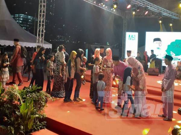 Menteri Besar Selangor Amirudin Shari menyampaikan duit raya kepada kanak-kanak.

