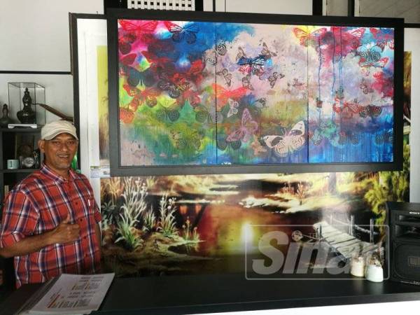 Ahmad Nazrin menunjukkan lukisan utamanya yang bertajuk Mencari Dia yang merupakan tema kepada pameran solonya di Restoran Seri Hijrah di sini.