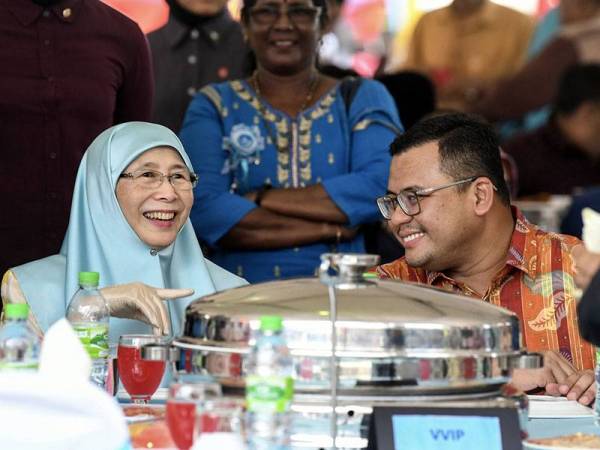 Timbalan Perdana Menteri Datuk Seri Dr Wan Azizah Wan Ismail (kiri) berkata sesuatu kepada Menteri Besar Selangor, Amiruddin Shari (kanan) ketika hadir pada Majlis Rumah Terbuka Aidilfitri Ahli Parlimen Pandan di Padang Majlis Perbandaran Ampang Jaya hari ini. - Foto Bernama