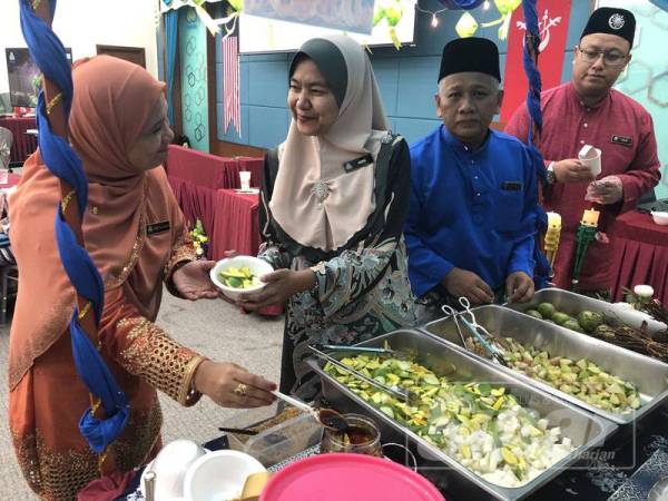 Nora melayan kakitangan Perkeso dan tetamu yang hadir di Majlis Sambutan Aidilfitri di Bangunan Perkeso Negeri hari ini.