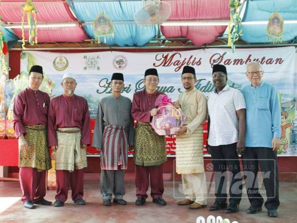 Dr Fadzli Cheah menyampaikan cenderahati kepada Mohd Yusof (kanan).