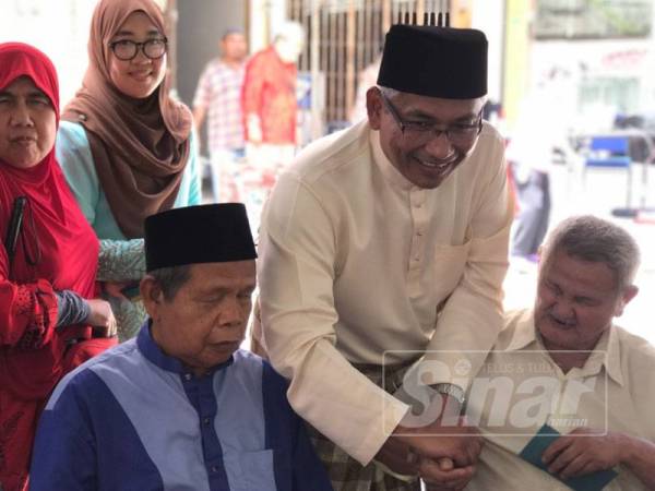 Abdul Aziz (tengah) bermesra dengan ahli Pertubuhan Orang Cacat Penglihatan Malaysia Perak pada Majlis Sambutan Hari Raya Aidilfitri 2019 kelmarin.