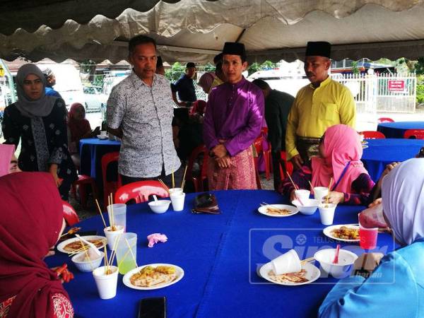 Sukiman (kiri) beramah mesra dengan anggota APM negeri Kedah sempena Sambutan Hari Raya Aidilfitri APM peringkat negeri Kedah di Pejabat APM Kuala Muda semalam.