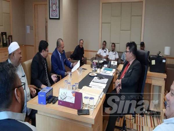 Abu Bakar Yahya (empat dari kiri) meneliti dokumen berkaitan isu teksi sambil diperhatikan oleh Datuk Mohamad Dahlan Md. Maamor di Kementerian Pengangkutan, Putrajaya hari ini.