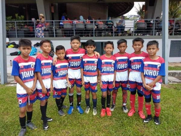 Muhammad Hazriq (lima,kanan) bersama rakannya ketika mewakili pasukan AT Johor dalam satu perlawanan bola sepak, baru-baru ini.