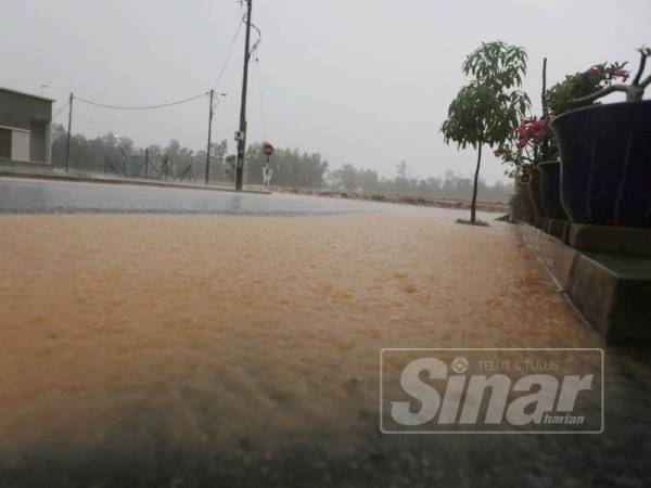 Air lumpur melimpah dari longkang yang tersekat alirannya.