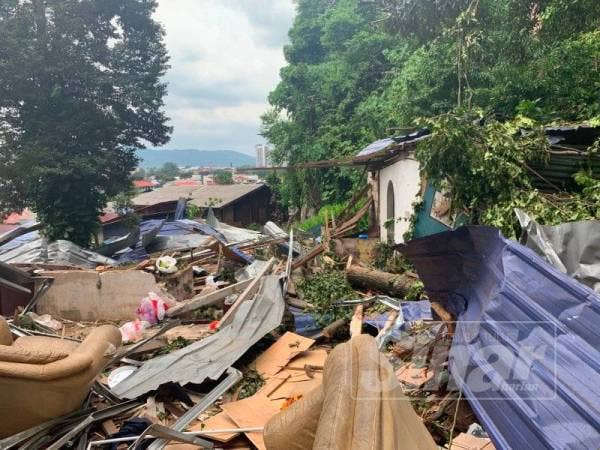 Keadaan rumah yang rebah ke bumi manakala bahagian tandas (kanan) tempat Kamarudin terperangkap masih elok.