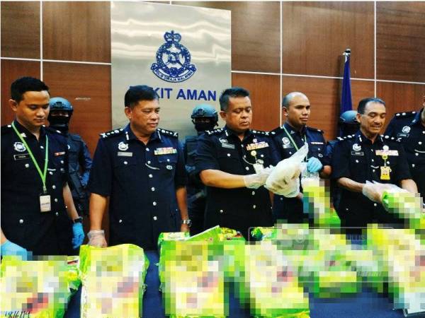 Kamarul Zaman (tengah) menunjukkan dadah dirampas ketika sidang media di Bukit Aman hari ini.