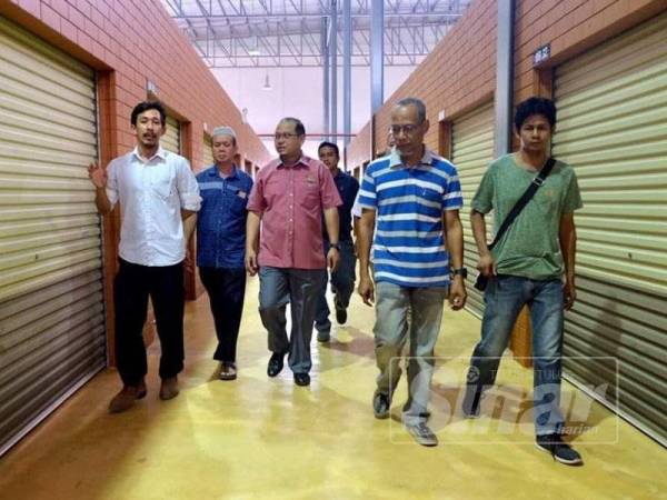 Zakaria (dua, kiri) bersama Ahli Parlimen Kuala Terengganu, Ahmad Amzad Hashim (tengah) meninjau keadaan bangunan sementara yang akan menempatkan peniaga Pasar Payang.