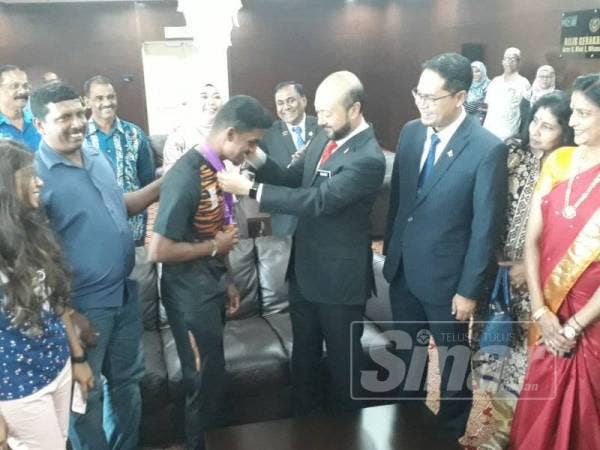 Mukhriz (tiga dari kanan) melihat medal emas Kejohanan Memanah Para Dunia 2019 yang dimenangi Suresh.