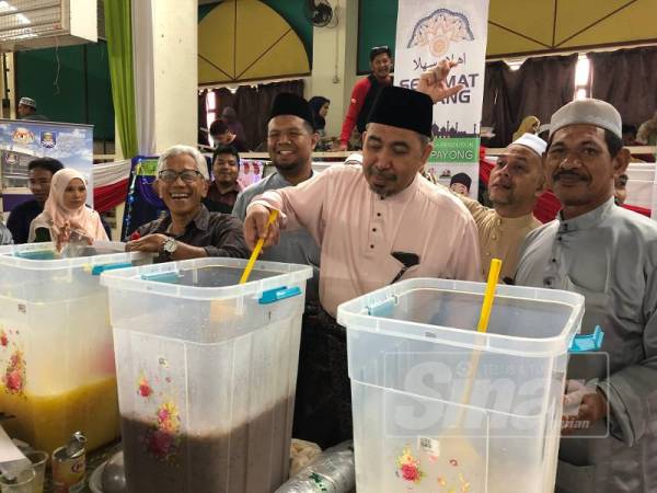 Izani bersama penghulu kampung menyediakan minuman untuk tetamu yang hadir.