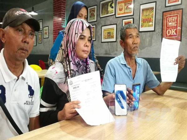 Hashimah (tengah) menunjukkan laporan polis dan gambar kecederaan dialami anak lelakinya didakwa akibat terkena tembakan di Jalan Langgar berdekatan Jalan Datuk Kumbar, hari ini.