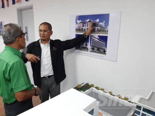 Pengerusi Eksekutif Kencana Healthcare Sdn Bhd, Datuk Ahmad Raziff Abu Bakar menunjukkan lakaran grafik projek pembangunan kepada Pengurus Besar PIJ, Abdul Rashid A Rahman.