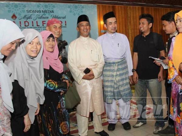 Nik Mohd Azlan (lima dari kiri) dan Murtadha (lima dari kanan) bermesra dengan pengamal media Kelantan di Majlis Jalinan Ukhuwah Aidilfitri Bersama MAIK di Dewan Besar, Kompleks Islam Lundang hari ini.