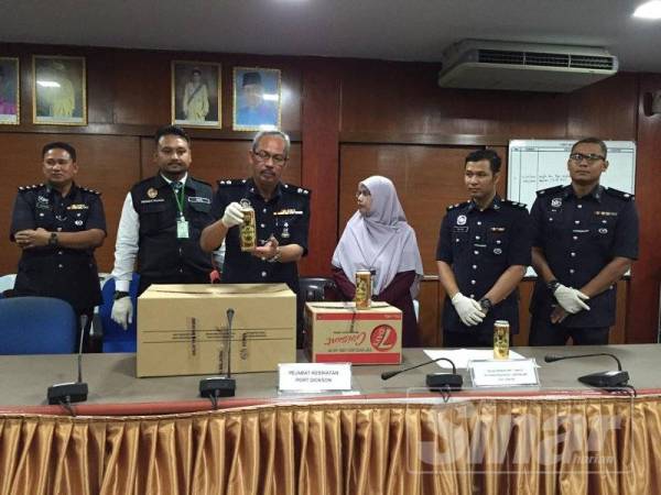 Aidi Sham menunjukkan arak yang dirampas pada sidang media hari ini.